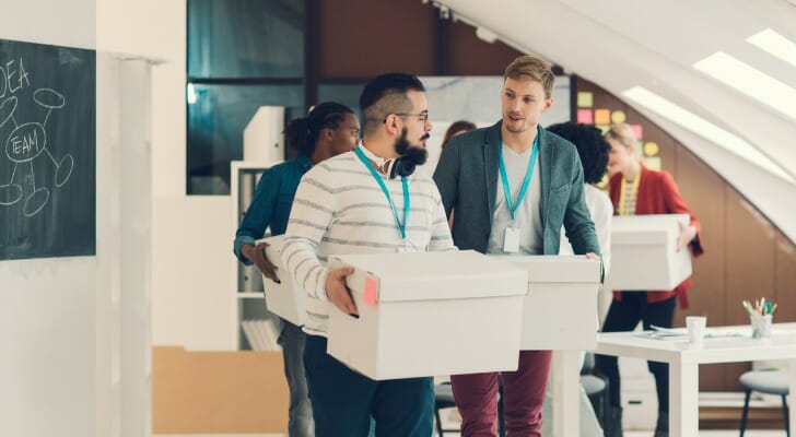 Image shows a group of works in a financial advisory firm moving packed boxes to a new headquarters. SmartAsset analyzed data to find