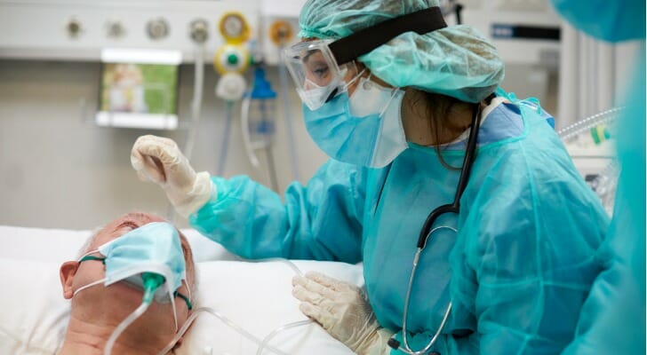 Image shows a nurse in a hospital attending to a patient. In this study, SmartAsset analyzed data from various sources to identify the best-paying places for nurses.