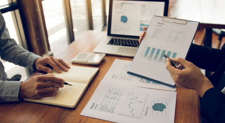 Image shows investment consultants analyzing some portfolio data.