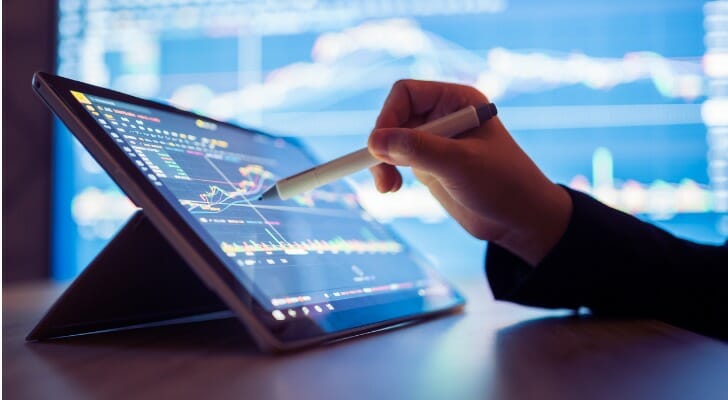 Investor looks at market data, considering whether to invest in a unit trust.