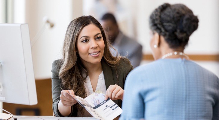 A woman shows a brochure to another woman.