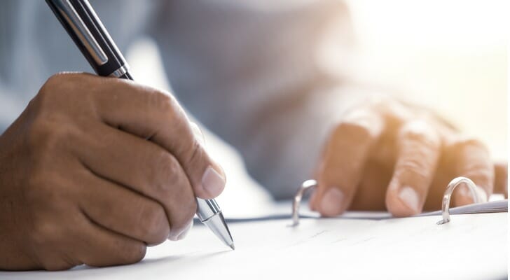 Closeup of a man signing an estate planning document.