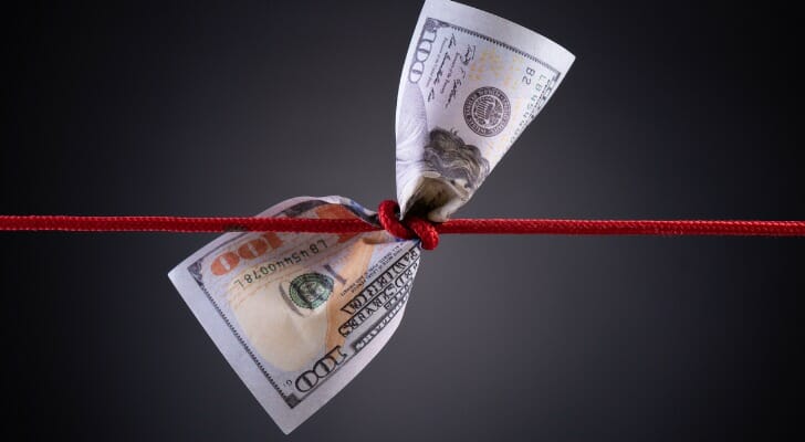 Red string tied around a dollar bill