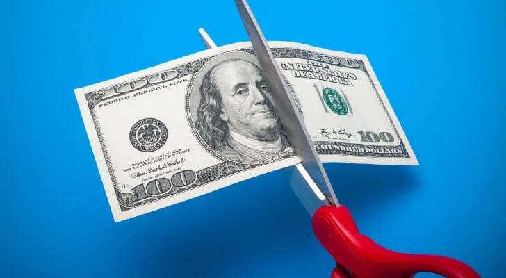 $100 bill being cut in half