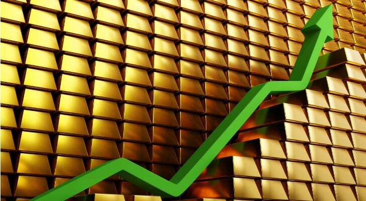 A gold price chart with a green arrow representing an increase in value.