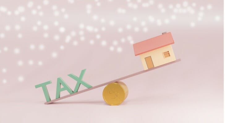 "TAX" and a toy house on a see-saw