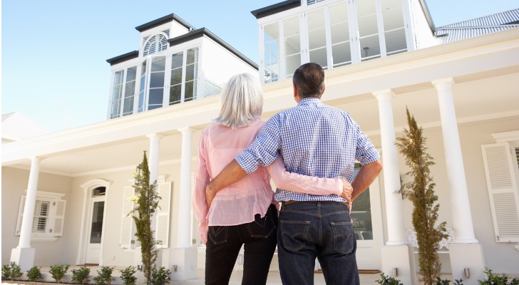 Image shows a senior couple looking up at their dream home. The FHFA is expected to raise the conforming loan limits to new heights next year.
