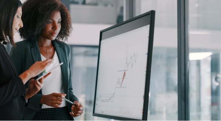 Two investors study a stock chart.