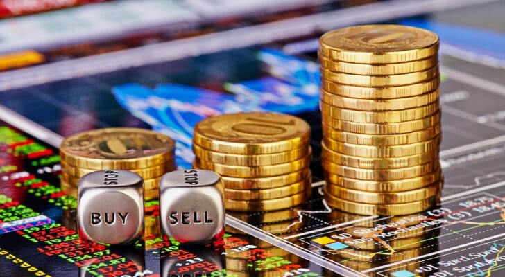 Stack of gold coins on a digital price chart.