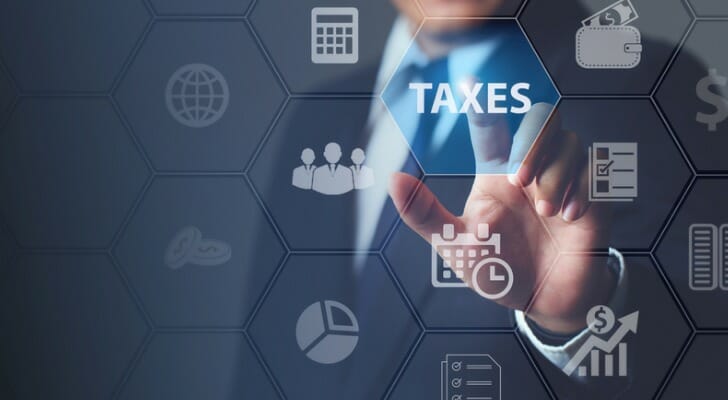 A man selecting "TAXES" on a secreen.