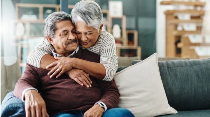 A married couple embraces as they discuss their retirement plan. SmartAsset compared 100 cities with the largest populations of people 65 and over to determine where Social Security benefits are highest and lowest compared to local housing costs.