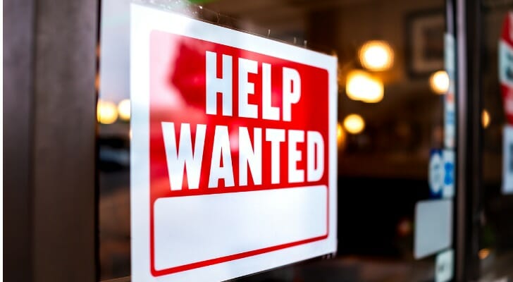 A help wanted sign hangs in the window of a store. SmartAsset studied where small businesses are having the most trouble hiring new employees.
