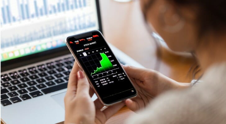 A trader reviews their investment account on their smartphone.
