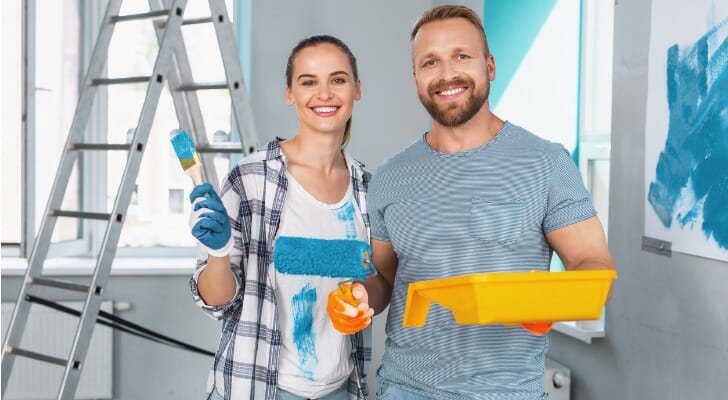 Young homeowners painting their house