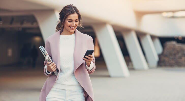 A woman checks her retirement portfolio using her phone. Research from Morningstar suggests those planning for retirement may to save twice as much as current retirees.