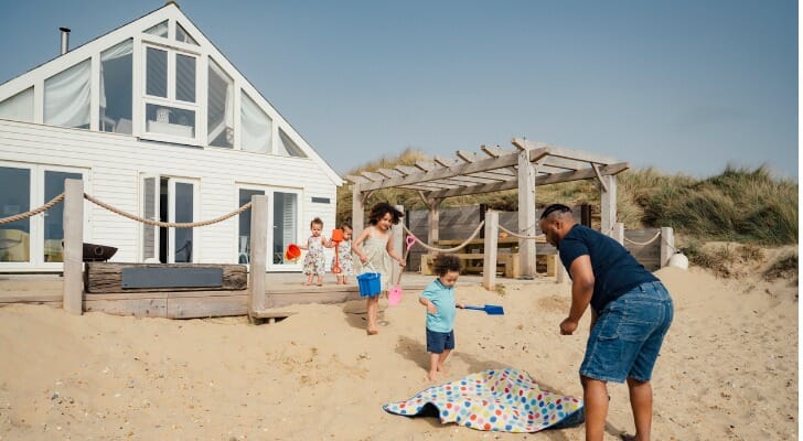 A family enjoys the beach in front of their vacation home. SmartAsset examined mortgage data to find the hottest vacation home markets in the U.S.