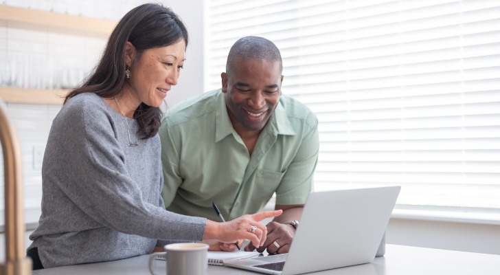 A couple checks their retirement portfolio using a laptop. Research from Morningstar suggests those planning for retirement may need to save twice as much as current retirees.