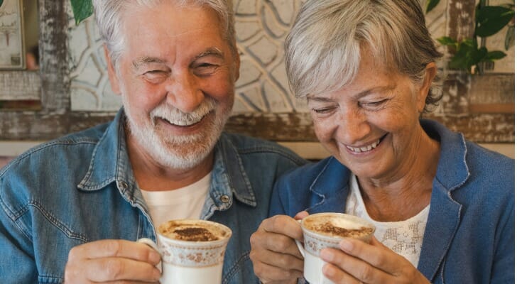 A couple discuss how to retire at 65 over coffee.
