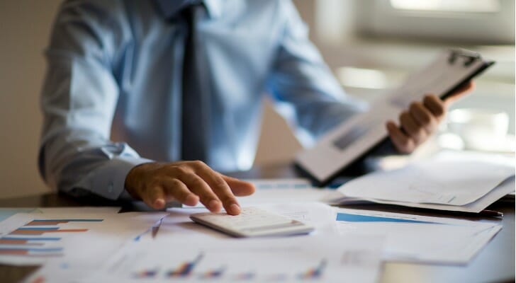 A financial advisor looks over investment data. Certified Financial Planners™ (CFP®s) are held to a fiduciary standard, which means they have to act in the best interests of their clients.