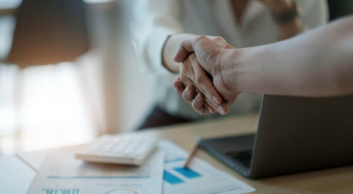 Husband and wife shake hands on their agreement to use a joint brokerage account.