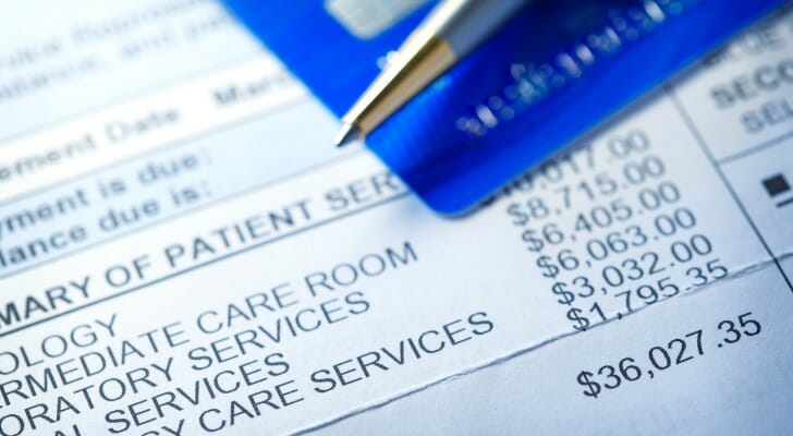 A credit card rests on top of a medical bill. A recent study found that a couple with median prescription drug expenses will need $296,000 in savings to cover their medical bills in retirement.