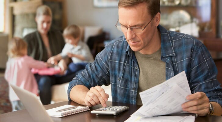 A husband reviewing financial documents for a family LLC.