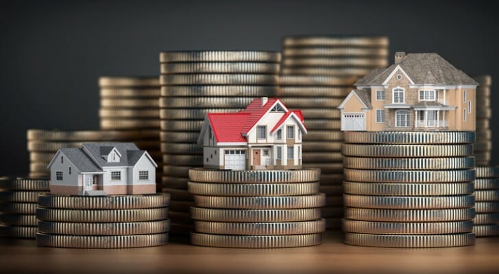 Toy houses on stacks of coins