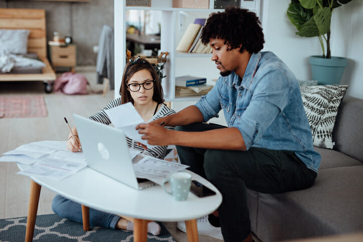 A couple preparing finance documents for a fee-only wealth management advisor.