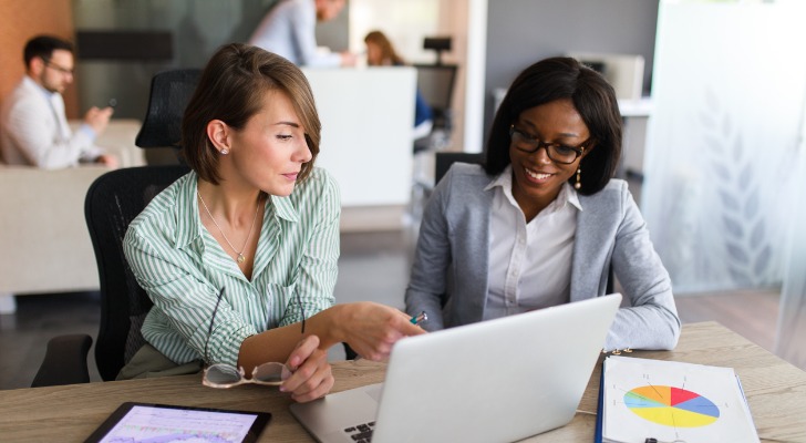 Image shows a new employee speaking with an HR rep about restricted stock units (RSUs) as part of an employee compensation package. SmartAsset dives deeper into RSUs.