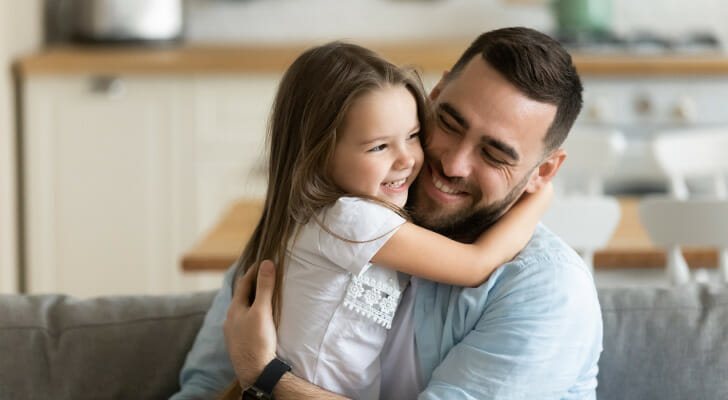 A father hugging his daughter, having learned how to create a trust for his child.