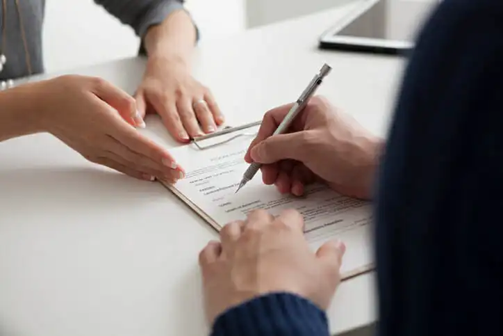 A trustee signing documentation for a trust account.