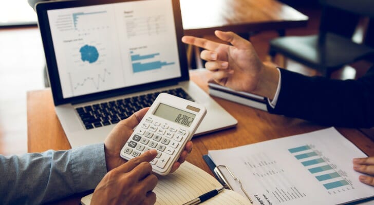 Image shows a financial advisor reviewing numbers and documents with a client. RSUs may factor into a long-term financial plan if your employer offers it as part of a compensation package.