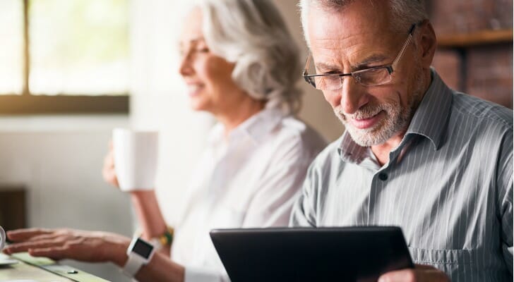 A retired couple goes over their finances together. A survey of over 1,500 senior homeowners found that single seniors are having a harder time financially compared to married couples.