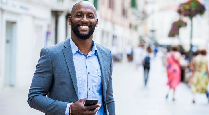 A high-net-worth investor in a suit, checking his phone.