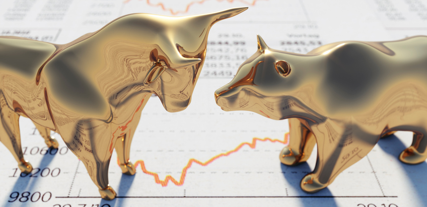 Bull and bear statues, symbolizing the ebb and flow of bull and bear markets, face one another on a stock market chart.