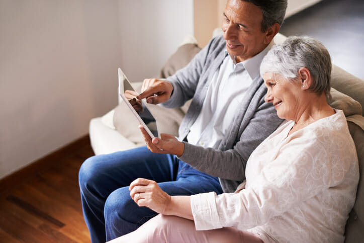 An older couple check their tax-deferred accounts, determining "Is it better to take RMD monthly or annually?"