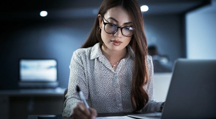 A woman calculating taxes on stocks at her computer.
