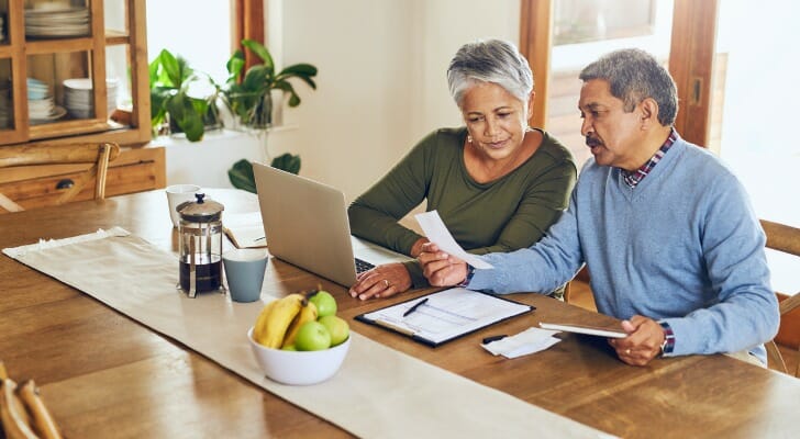 A retired couple works on their finances. J.P. Morgan has developed precise income replacement targets based on a retiree's pre-retirement income.