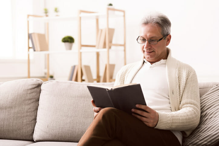 Man reading a book how to do a thrift savings plan rollover to IRA.