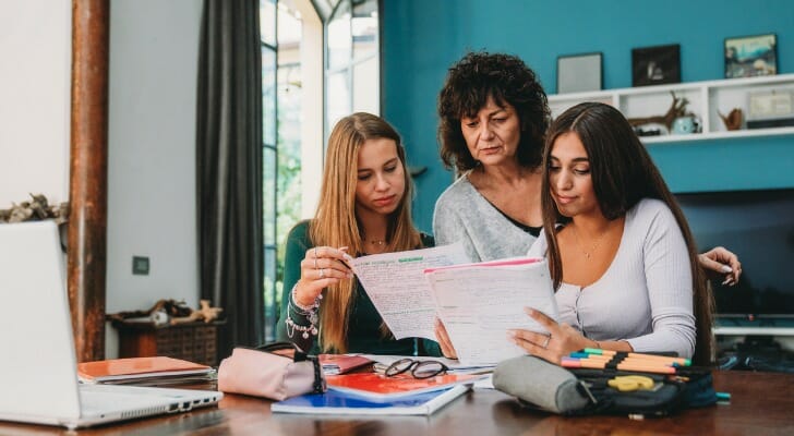 A mother helps her two daughters fill out college applications. A study from JPMorgan Chase found that overfunding a 529 savings plan can cost you big at tax time.