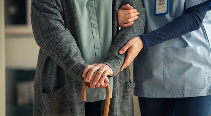 A nurse walks with a patient in a nursing home.