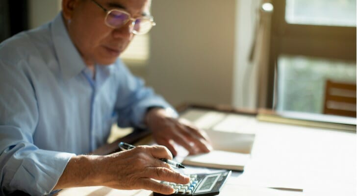 A retiree adds up his expenses and income. T. Rowe Price says some retirees should rethink the conventional approach to withdrawing retirement funds.