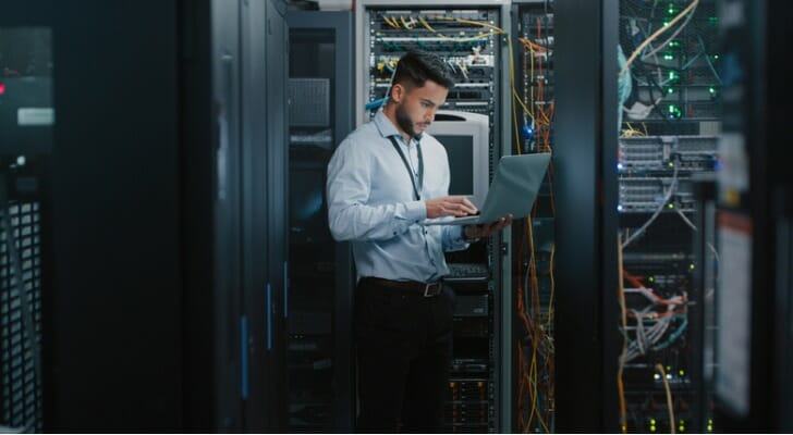 A young computer engineer works on his laptop in a server room. SmartAsset we compared the number of young people working various occupations in 2017 and 2021 to determine which ones are growing fastest.