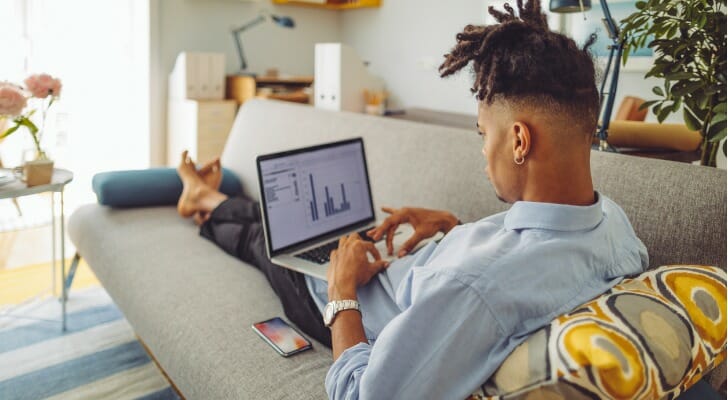 A investor looks at his portfolio on his laptop. Traditional IRAs and brokerage accounts are both vehicles you can make investments with. However, which is best for you depends on your needs and goals.