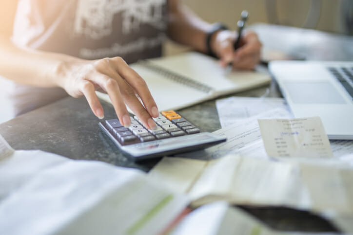 A woman calculates how much interest $10,000 earns in a year.