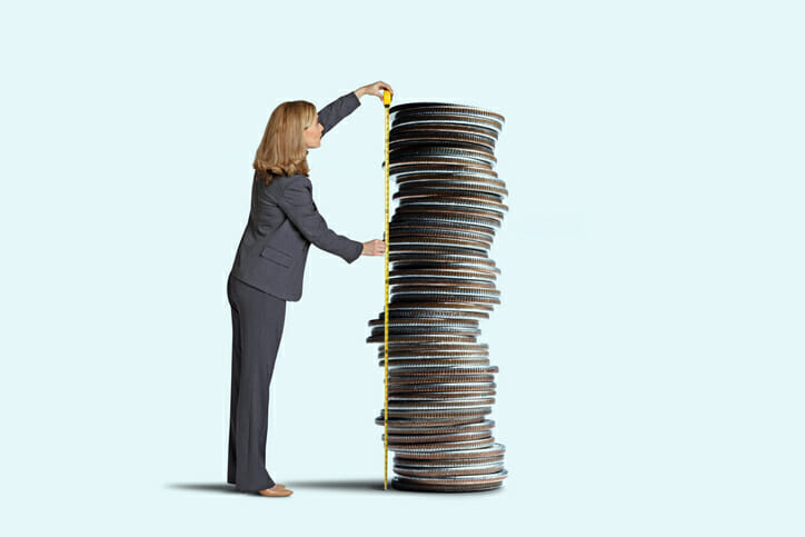 A woman measuring a stack of coins.