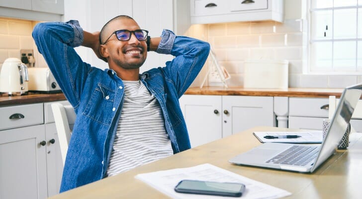 A young investor at his kitchen table, reviewing add-on certificates of deposit, or add-on CDs.