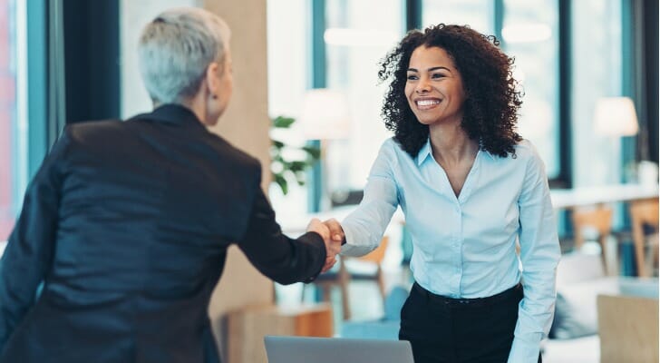 A financial advisor shakes hands with her client. Fidelity has launched two alternative asset funds that are available through advisors.