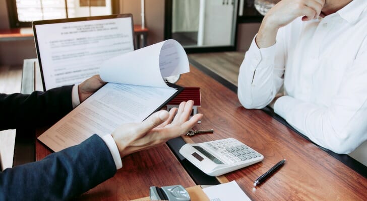 A potential homebuyer speaking with their financial advisor before buying a house.