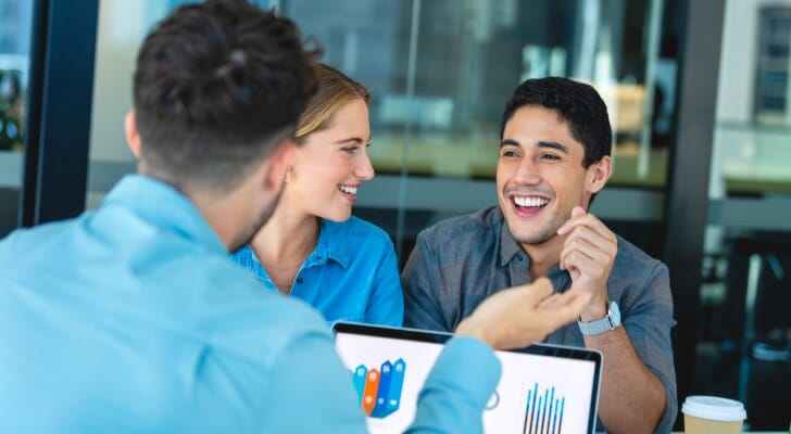 A couple meet with their financial advisor before buying a house.